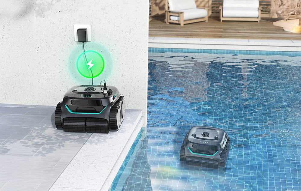 Dva černé robotické čističe bazénů s tyrkysovými akcenty, jeden se nabíjí na okraji bazénu s ikonou zeleného blesku, druhý čistí dno bazénu