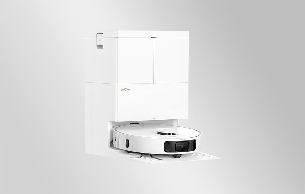 Bílý úklidový robot Mova zaparkovaný ve vysoké čtvercové dokovací stanici na světle šedém pozadí